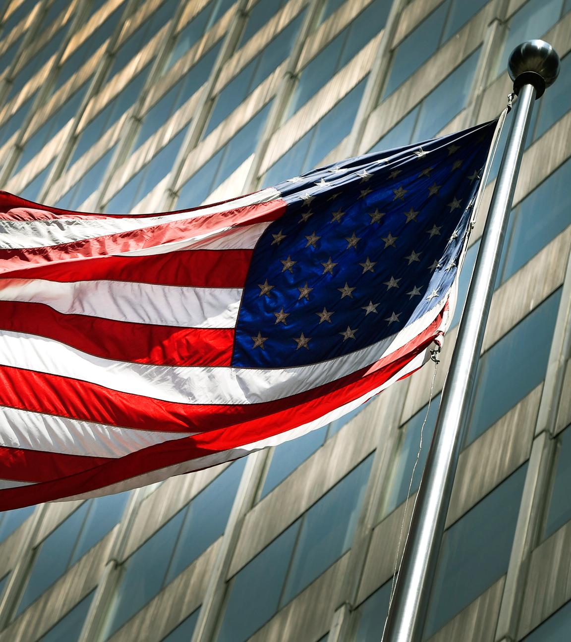 US-Flagge vor Büro-Hochhaus