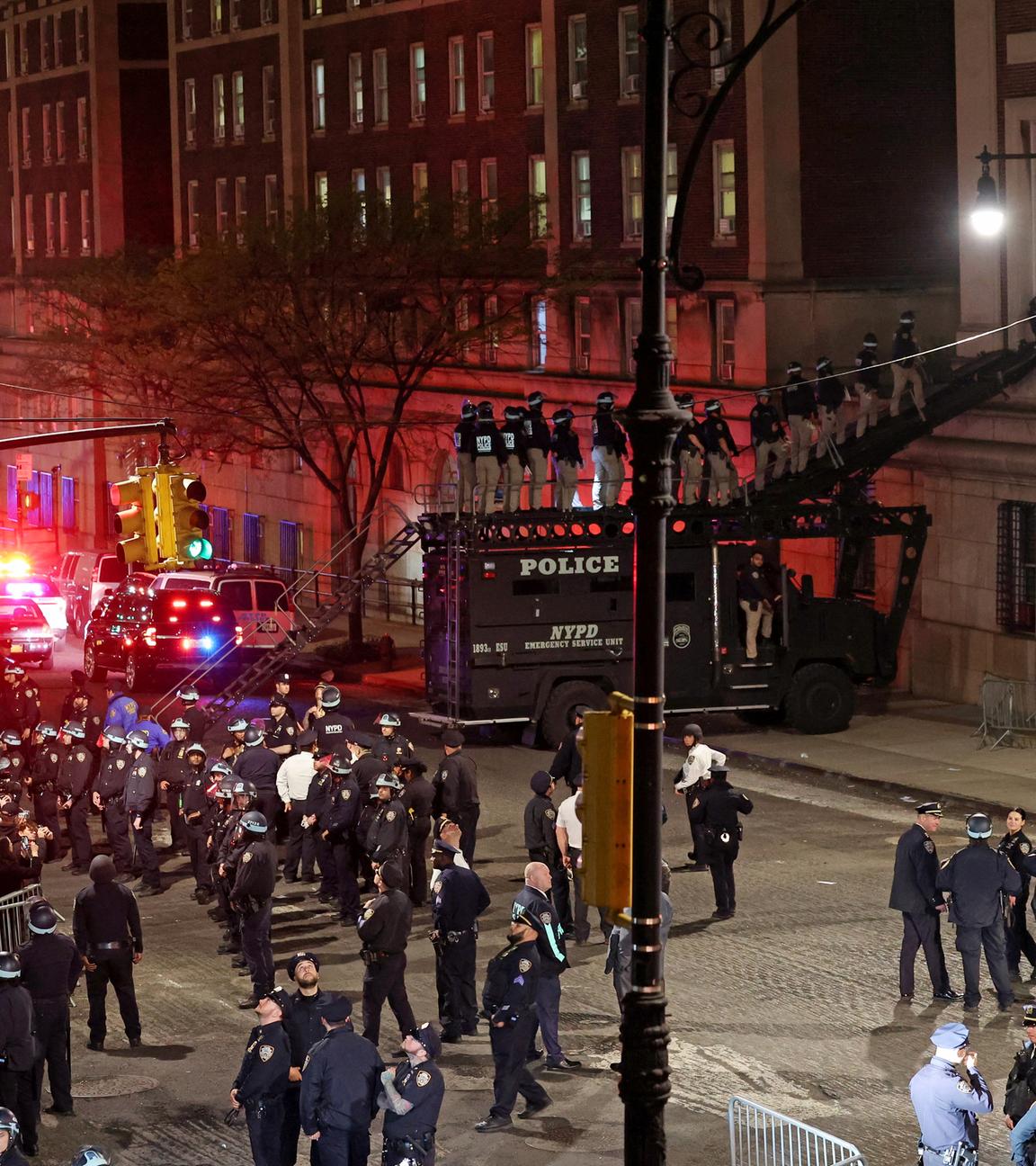 Die Polizei nutzt ein Spezialfahrzeug, um in die von Demonstranten besetzte Hamilton Hall einzudringen, während andere Beamte den Campus der Columbia University betreten