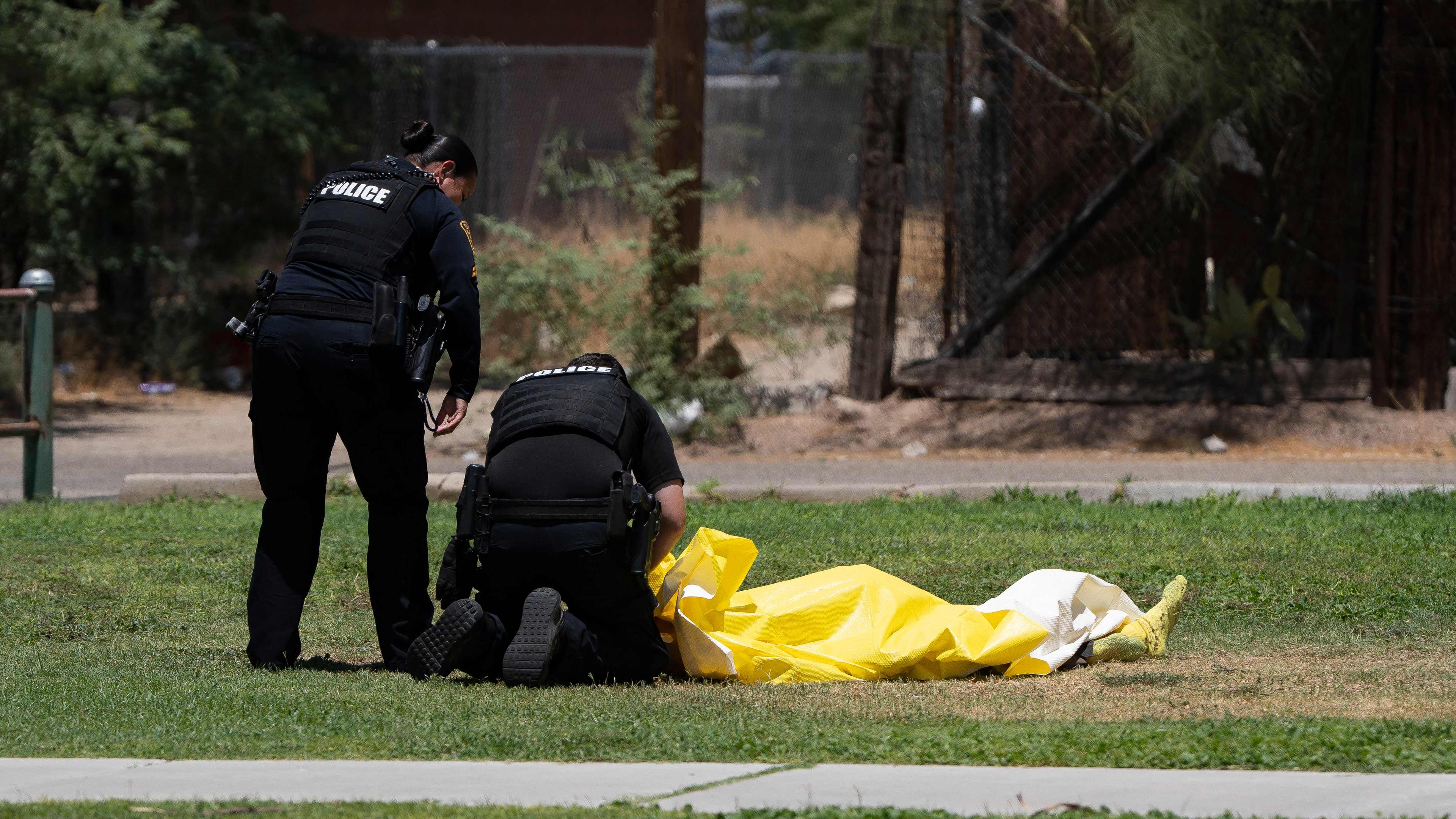 Polizeibeamte aus Tucson kümmern sich am 15. Juli 2023 im Estevan Park in Tucson, Arizona, um eine verstorbene Person, deren Körpertemperatur zum Zeitpunkt der Entdeckung 102 Grad Fahrenheit (fast 39 Grad Celsius) betrug und von der man annimmt, dass sie an den Komplikationen der extremen Hitze gestorben ist.