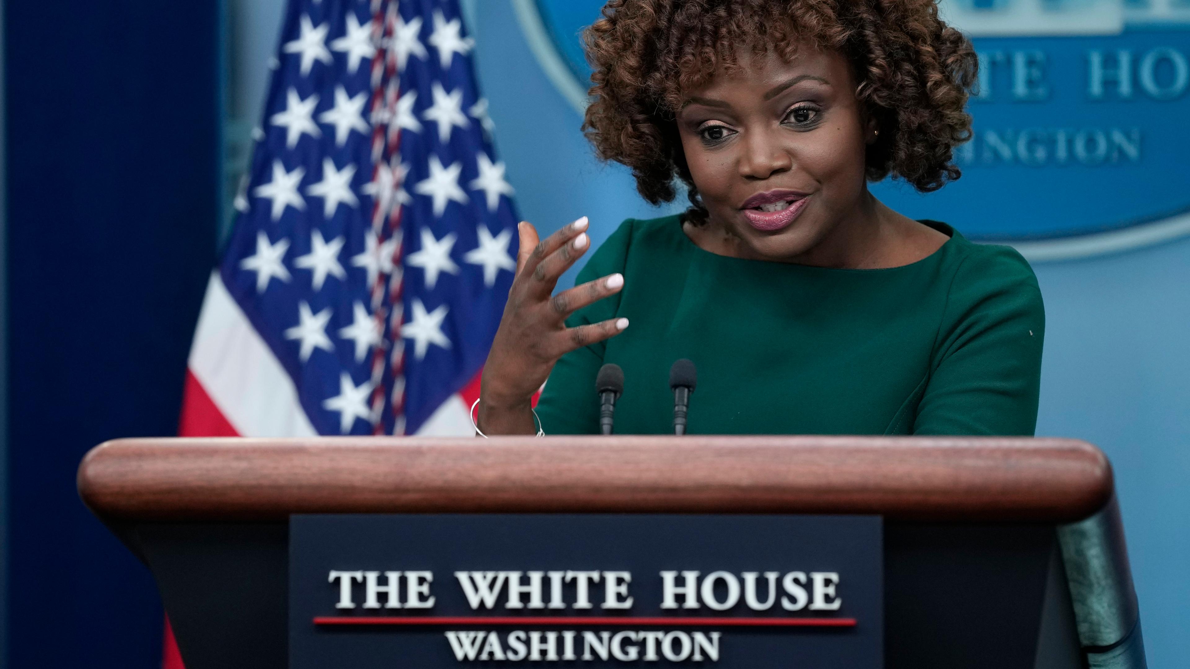 Karine Jean-Pierre, Sprecherin des Weißen Hauses, steht bei einer Pressekonferenz an einem Pult mit der Aufschrift "The White House"