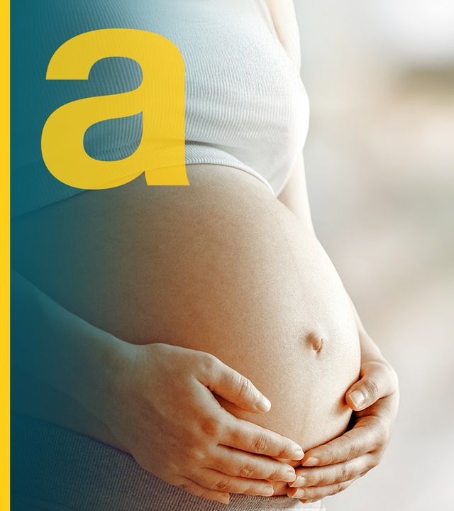 Der Bauch einer schwangeren Frau, die die Hände am Bauch hält