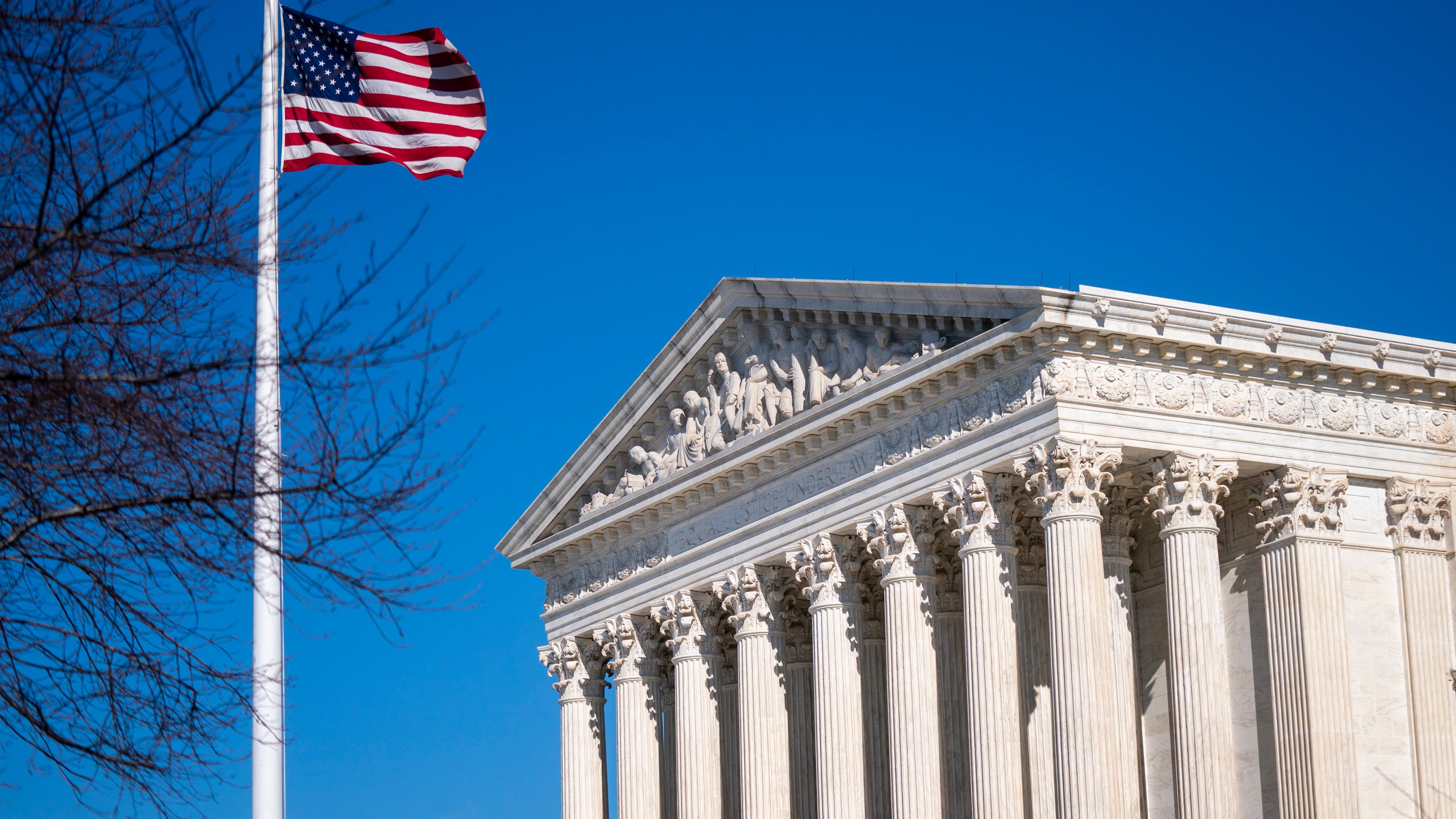 Links die Flagge der USA an einem Fahnenmast, rechts der oberste Gerichtshof der USA.