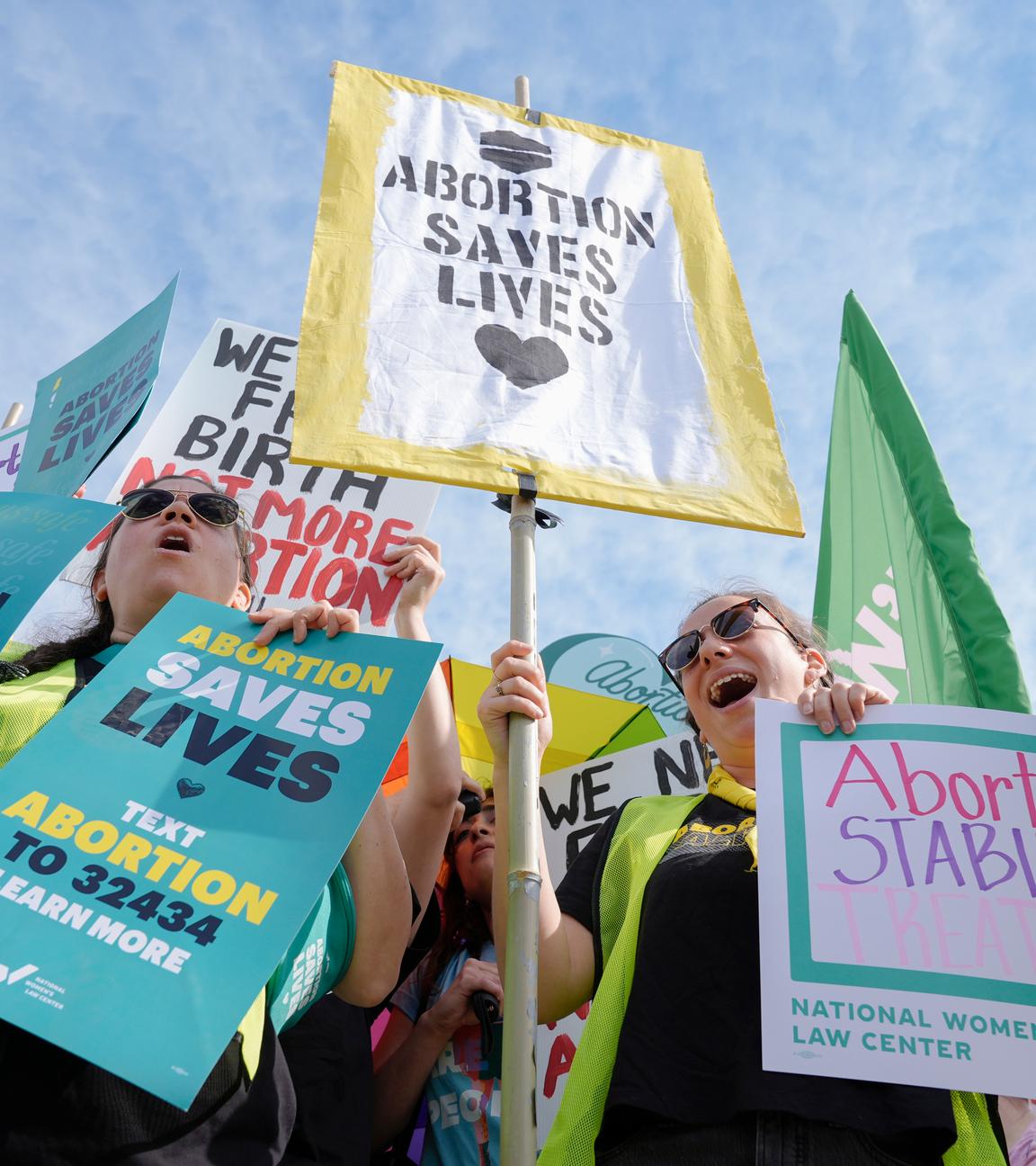 Aktivisten protestieren halten bunte Schilder mit der Aufschrift "ABORTION SAVES LIVES" und weiteren Forderungen für das Recht auf Abtreibung in den USA hoch