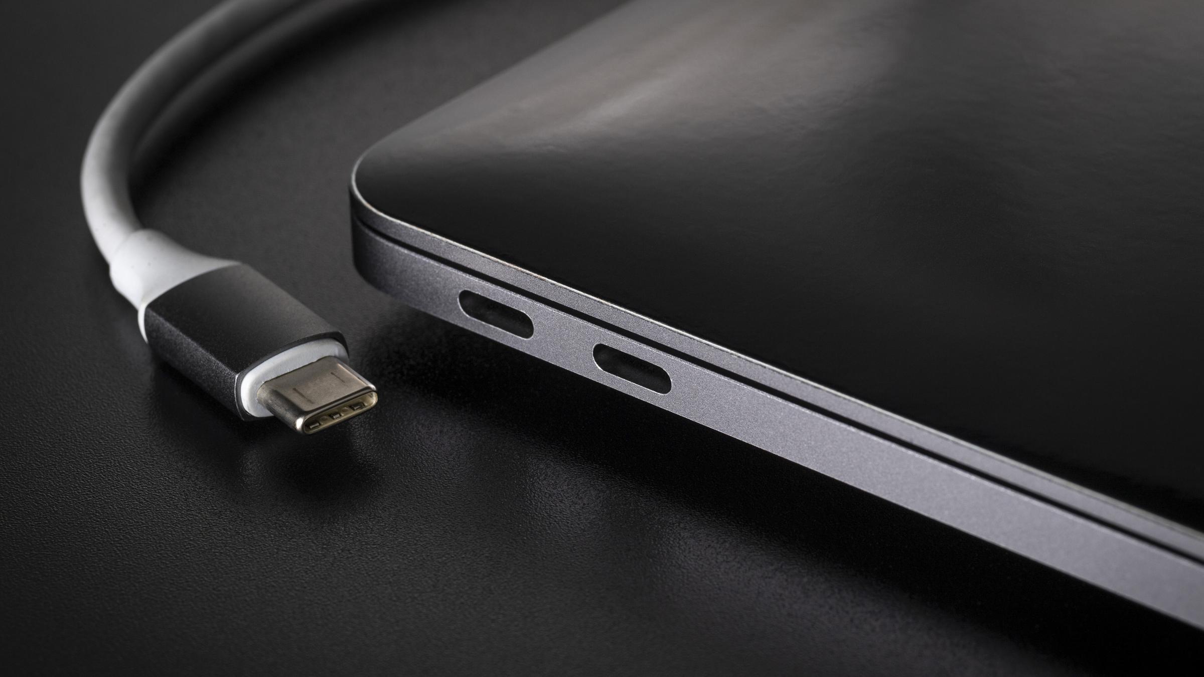 Ein vom Laptop getrenntes USB-Kabel vom Typ C auf schwarzem Hintergrundl