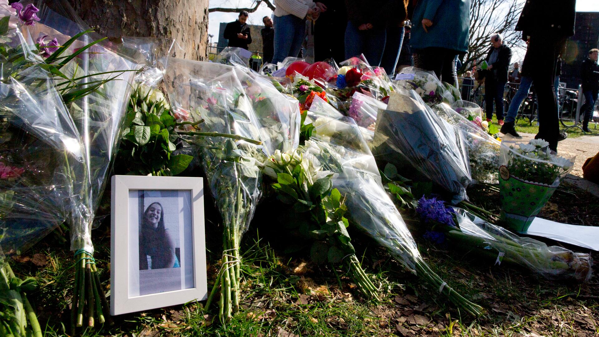 Blumen werden vor einem Foto der Opfer abgelegt