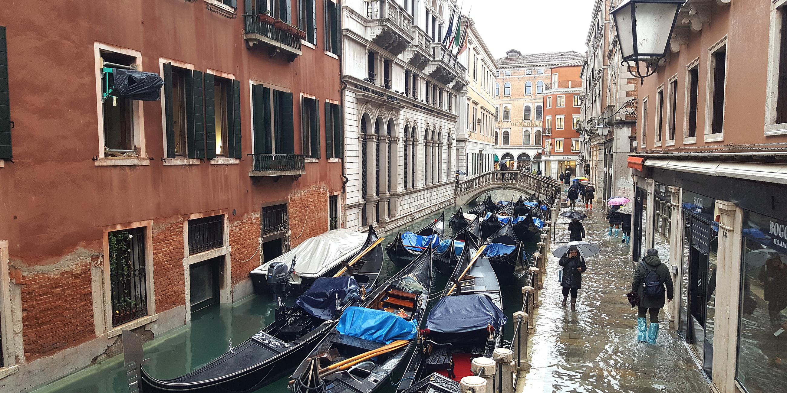 Boote und Gondeln in einem Kanal in Venedig.