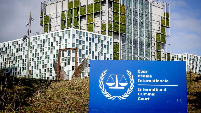 Das Gebäude des internationales Strafgerichtshofes. Im Vordergrund steht en Schild auf dem steht: International Crime Court.