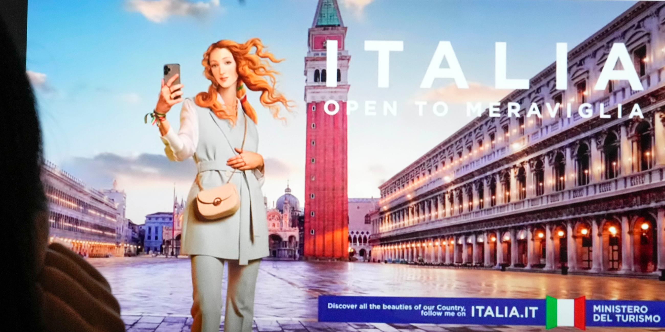 Menschen sehen sich auf einem Monitor die neueste Kampagne des italienischen Tourismusministeriums an, die Botticellis Venus zeigt, die in Rom als virtueller Influencer dargestellt wird.