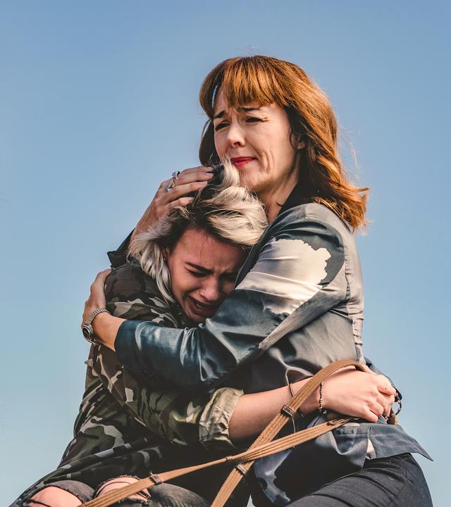 Amanda nimmt die weinende Issie in den Arm. Links neben den beiden steht Blaze.