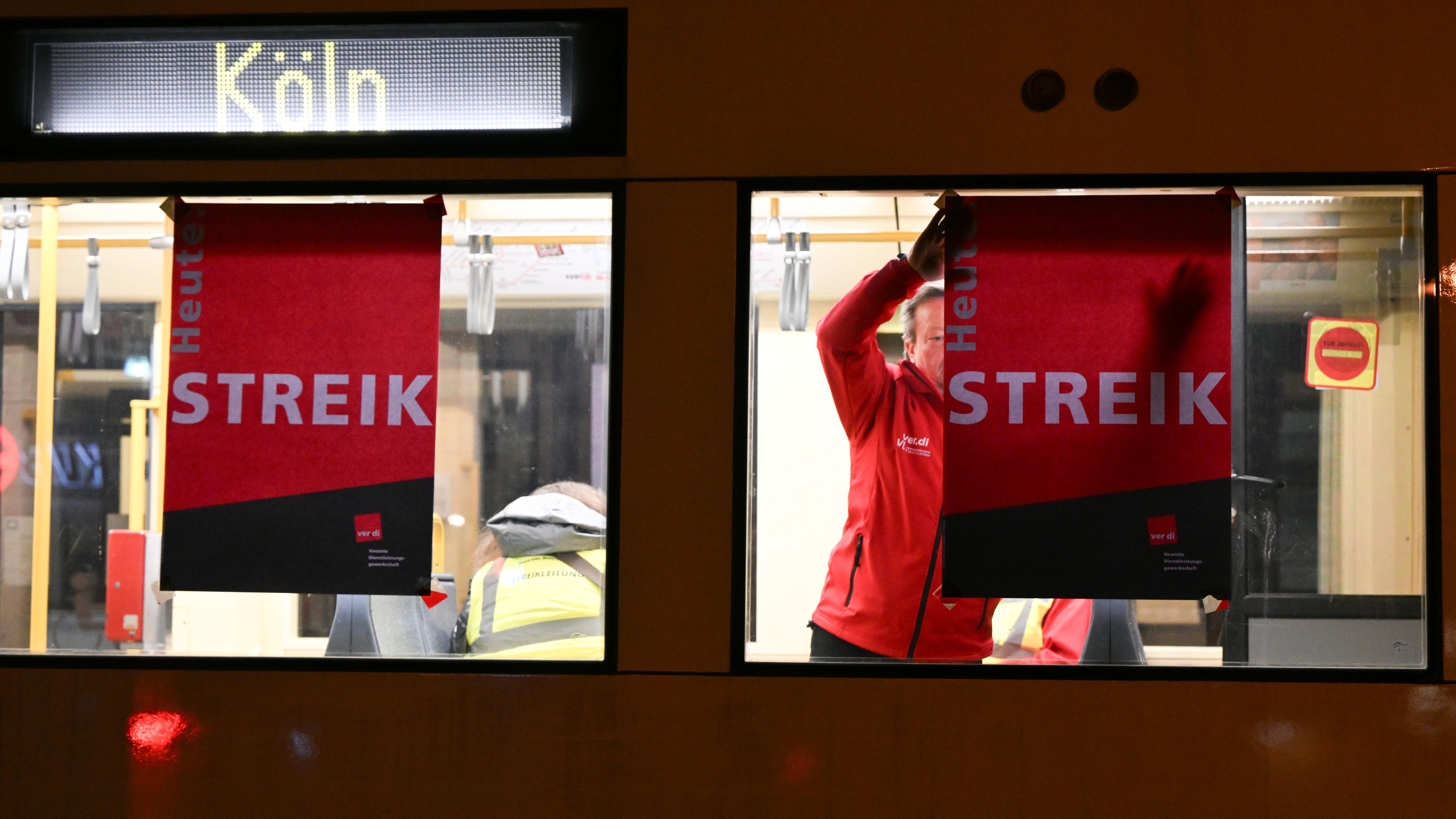  Nordrhein-Westfalen, Köln: Ein Streikender bringt ein Plakat mit der Aufschrift ·Streik· an einer Straßenbahn an. 