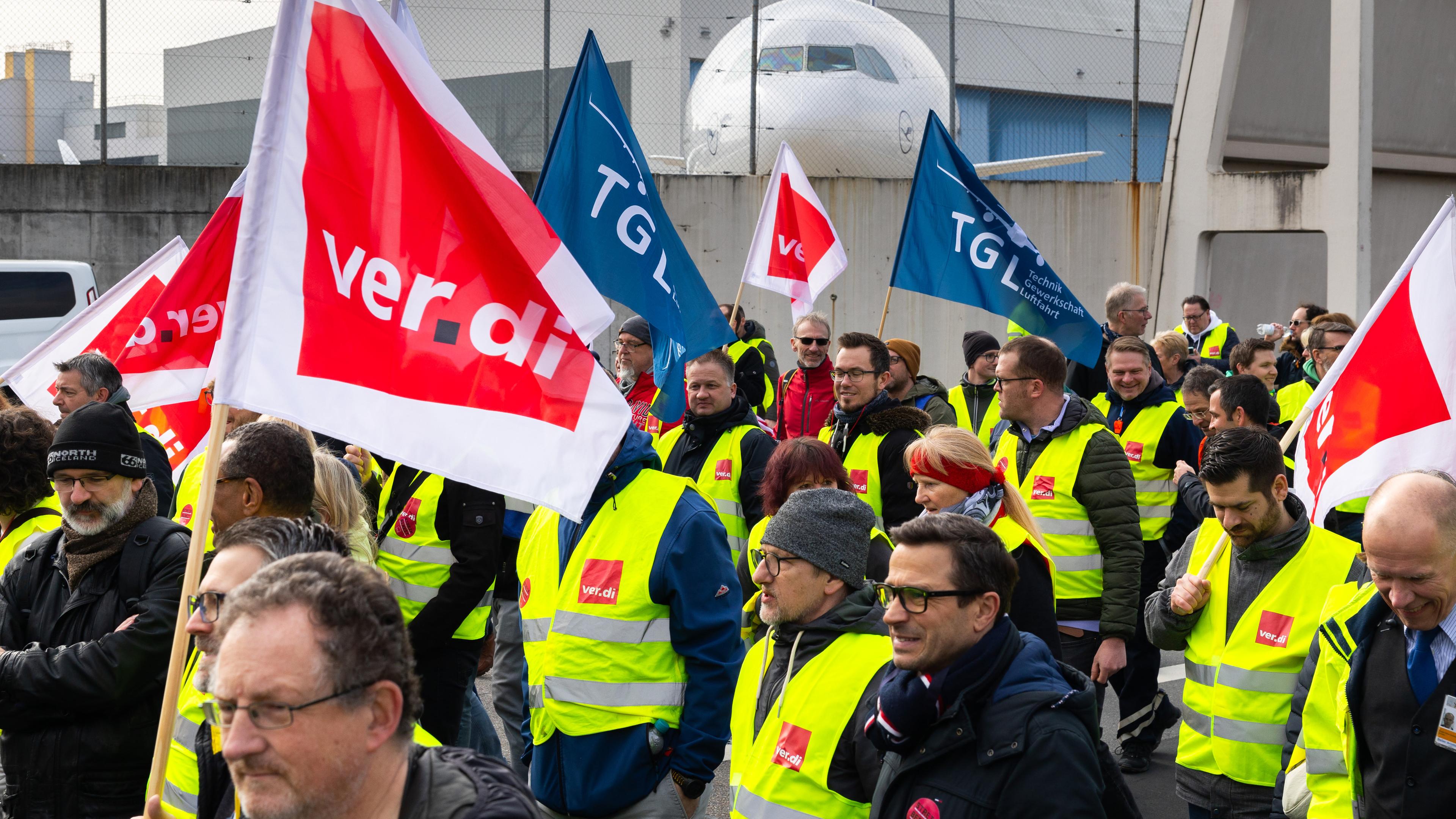 Hessen, Frankfurt/Main: Ein Protestzug von Streikenden zieht mit Bannern und Verdi-Fahnen vom Lufthansa Aviation Center zum Terminal 1.