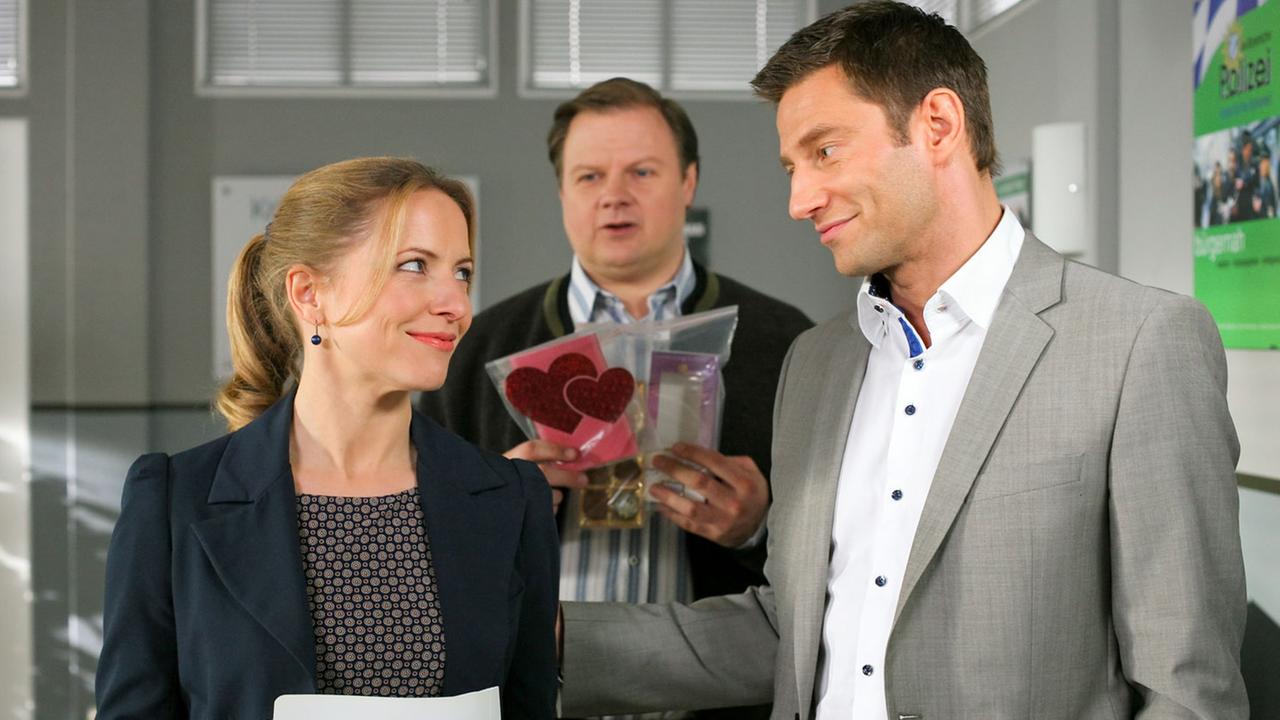 "Die Rosenheim-Cops - Vergiftetes Glück": Im Flur des Kommissariats stehen Controllerin Ortmann (Diana Staehly) und die Kommissare Hansen (Igor Jeftic) und Hartl (Michael A. Grimm).