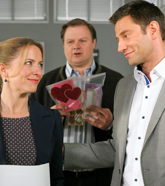 "Die Rosenheim-Cops - Vergiftetes Glück": Im Flur des Kommissariats stehen Controllerin Ortmann (Diana Staehly) und die Kommissare Hansen (Igor Jeftic) und Hartl (Michael A. Grimm).