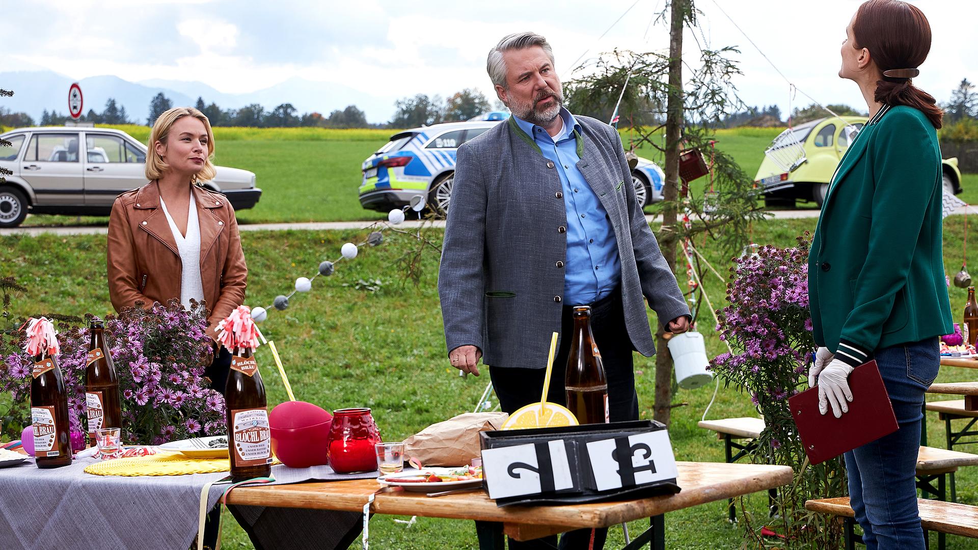 Kommissarin Winter (Vanessa Eckart), Kommissar Stadler (Dieter Fischer) und Pathologin Mai (Sina Wilke) stehen auf einer Wiese und unterhalten sich. 