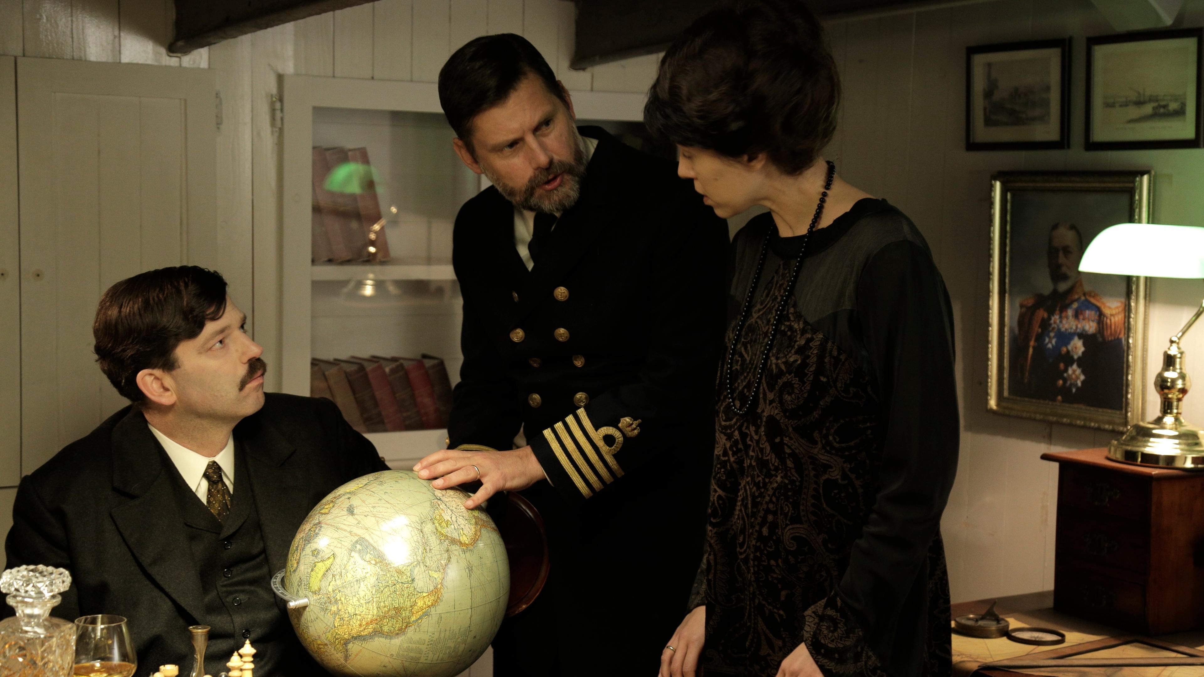 "Verrat!' - Das Ende der Habsburger im Ersten Weltkrieg": Spielszene: Karl, Zita und Kaptitän Snagge (Darsteller unbekannt) sitzen vor einem Globus und schauen, wo die Reise auf der Glowworm hingehen wird.