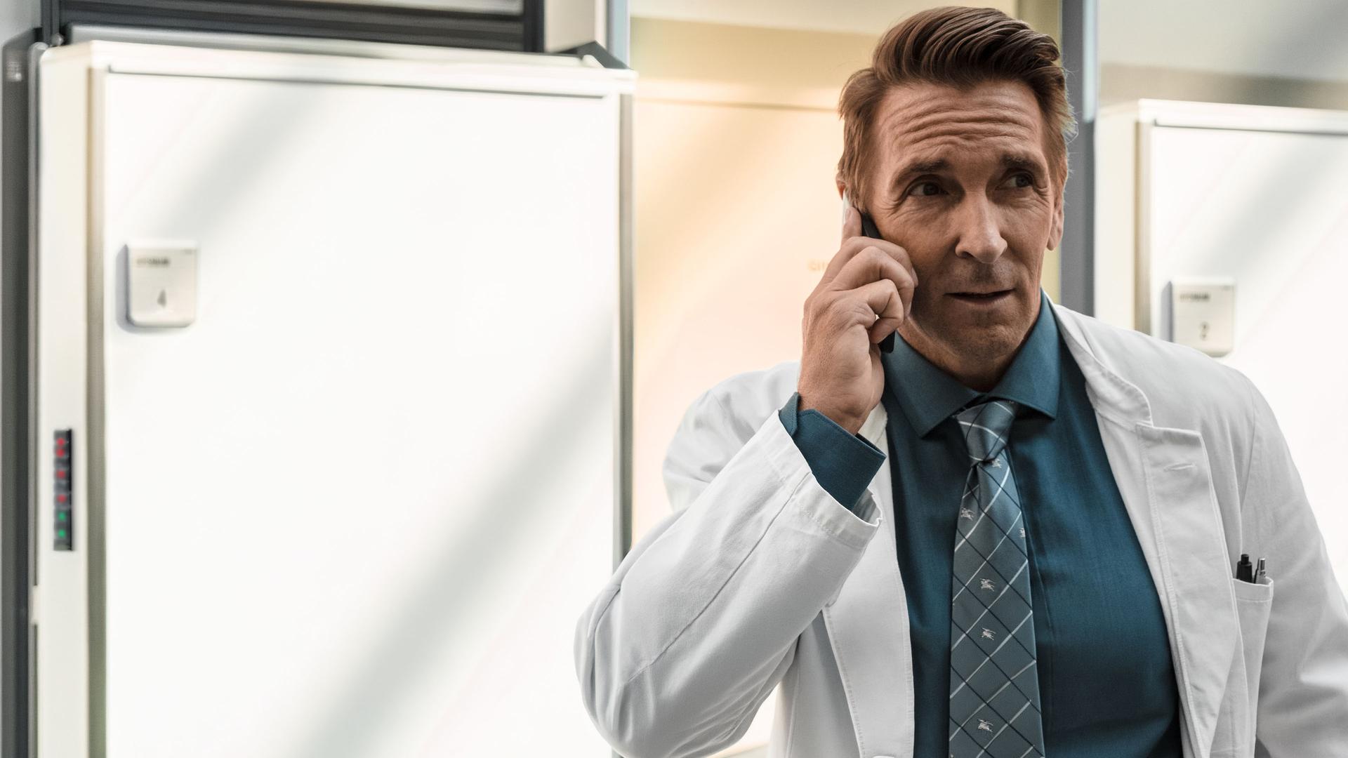 Dr. Alexander Kahnweiler (Mark Keller) telefoniert im Krankenhausflur.