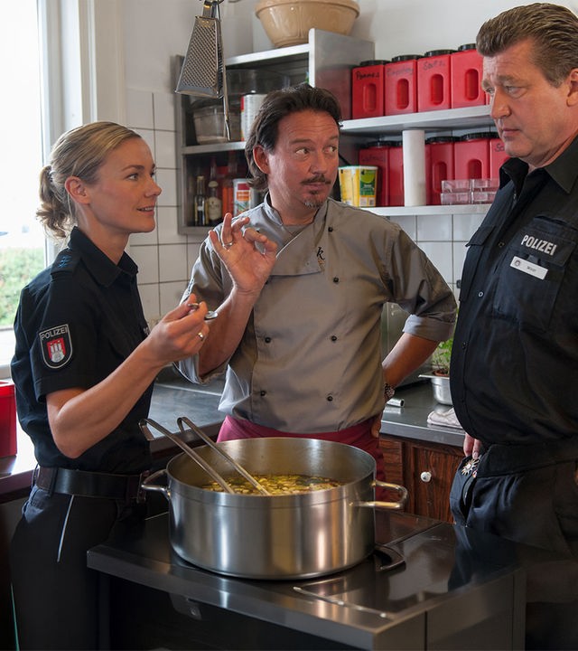 "Notruf Hafenkante - Versuchungen": Franzi (Rhea Harder), der Koch (Kolja Kleeberg) und Hans (Bruno F. Apitz) stehen am Herd.