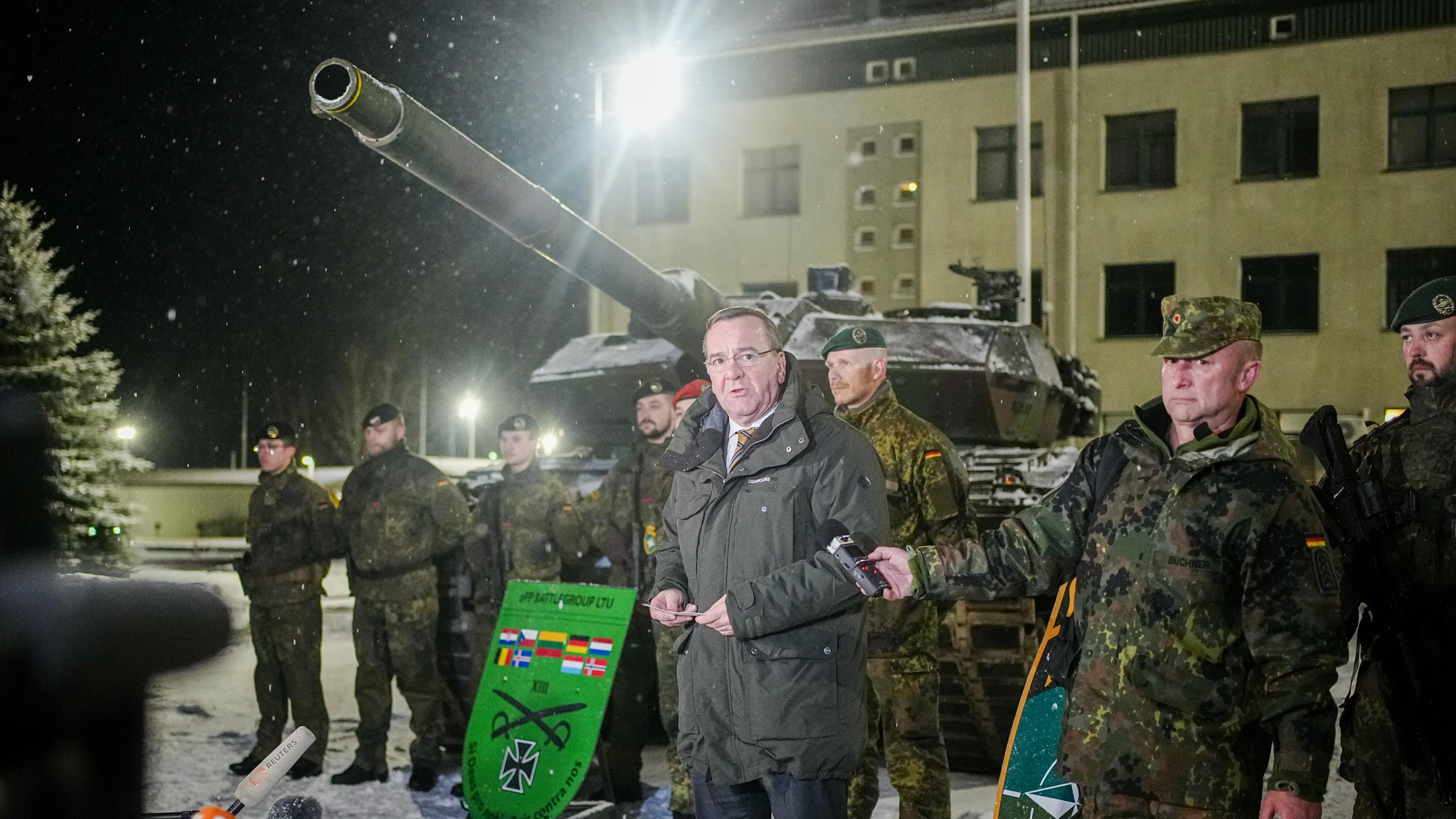 Litauen, Rukla: Boris Pistorius (SPD), Bundesminister der Verteidigung, spricht neben Bundeswehrsoldaten des deutschen Einsatzkontingents Enhanced Forward Presence in Rukla bei dem Besuch des Nato-Partners Litauen an einem Leoprd 2 Panzer zu den Journalisten. 