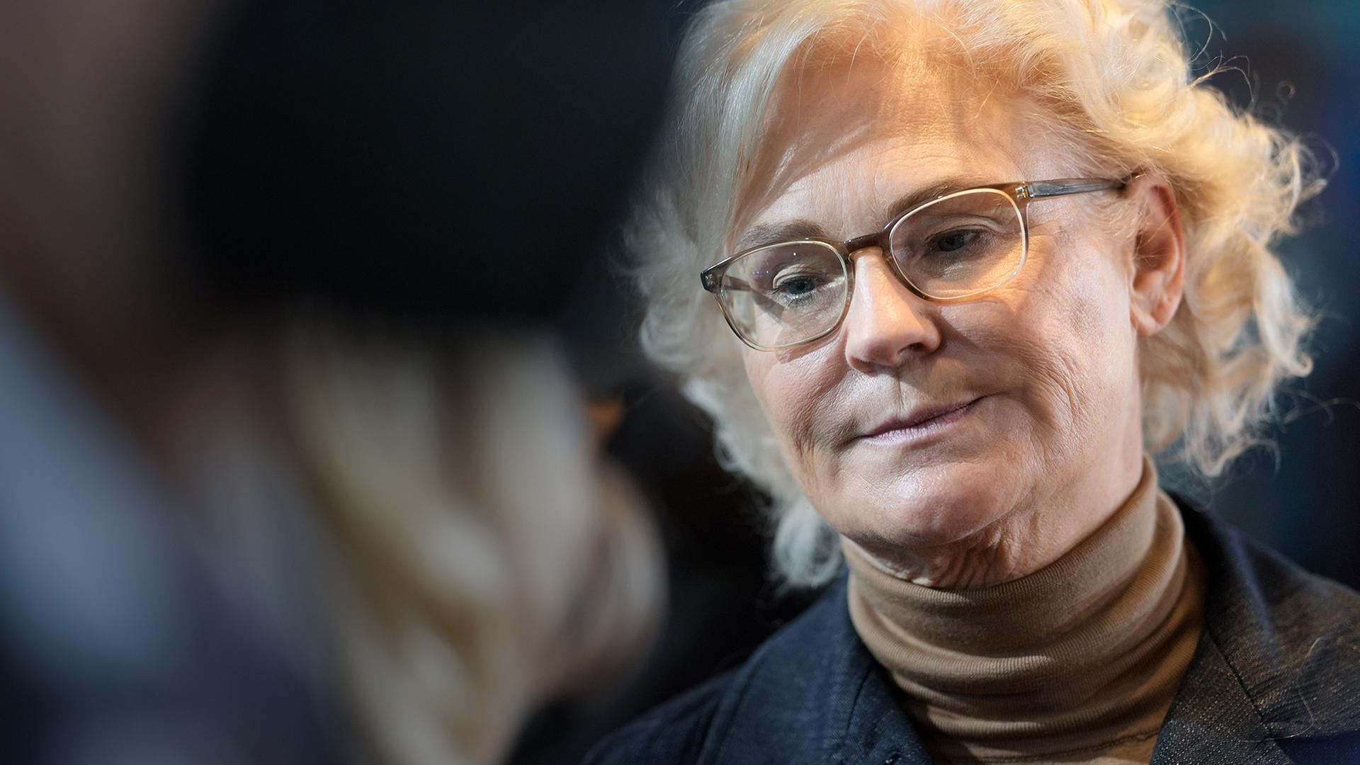 Christine Lambrecht vor dunklem Hintergrund. Sie schaut zu Boden.