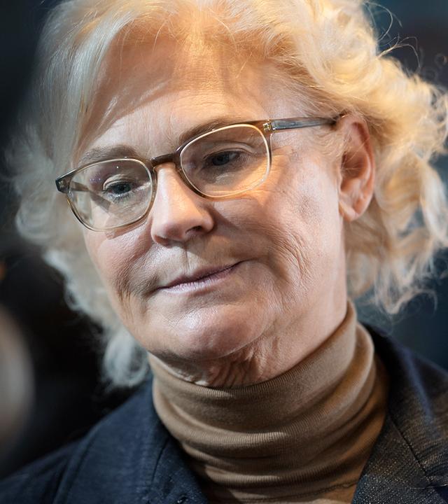 Christine Lambrecht vor dunklem Hintergrund. Sie schaut zu Boden.