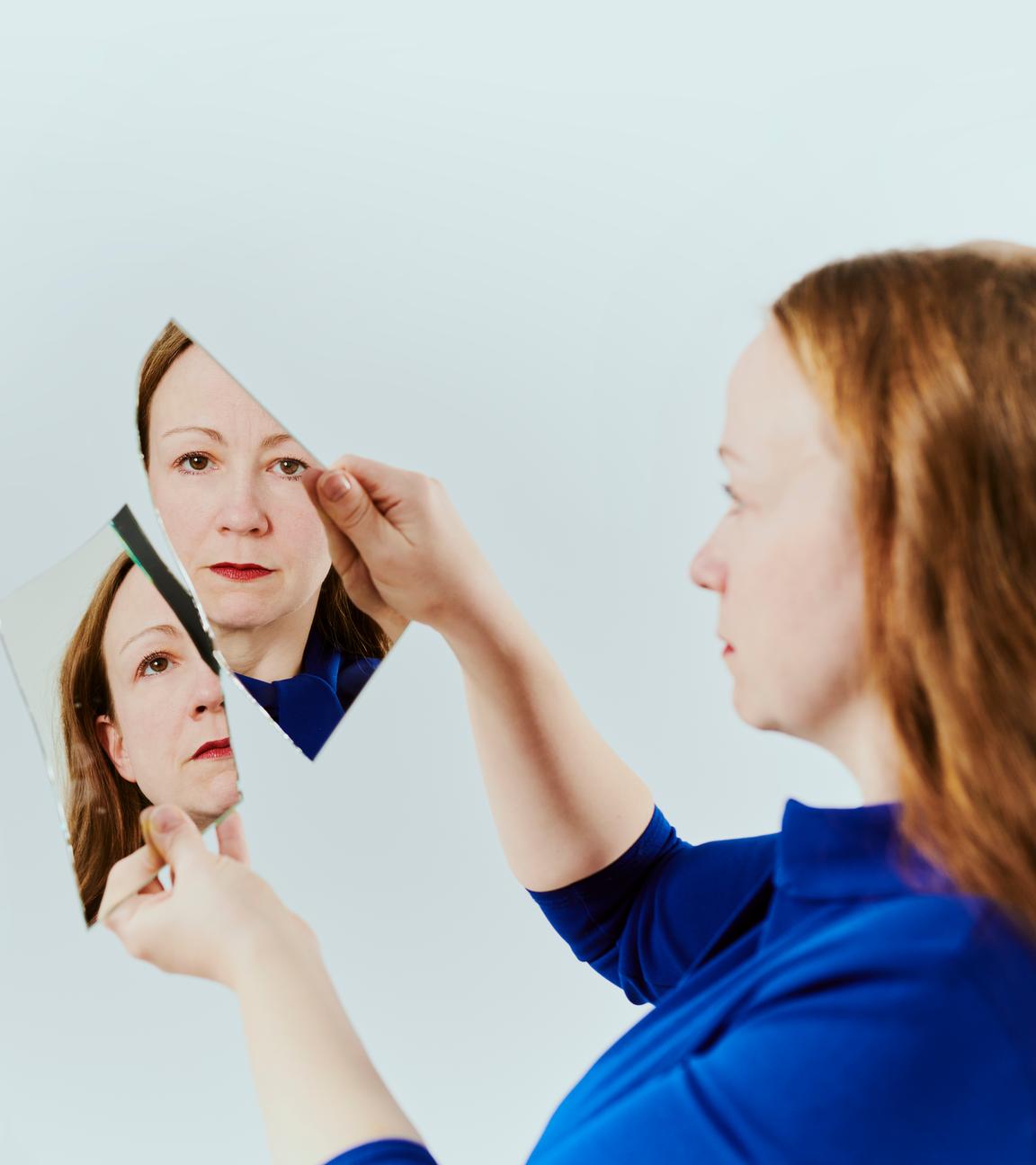 Zwei Spiegelscherben werden von zwei Händen hochgehalten. Im Spiegelbild zusehen ist Alexandra.