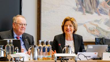 Malu Dreyer, Vorsitzende des ZDF-Verwaltungsrats, und Peter Heesen sitzen nebeneinander während einer ZDF-Verwaltungsratssitzung am Konferenztisch. Das Bild zeigt sie in einer Arbeitssituation mit Technik und Sitzungsunterlagen.