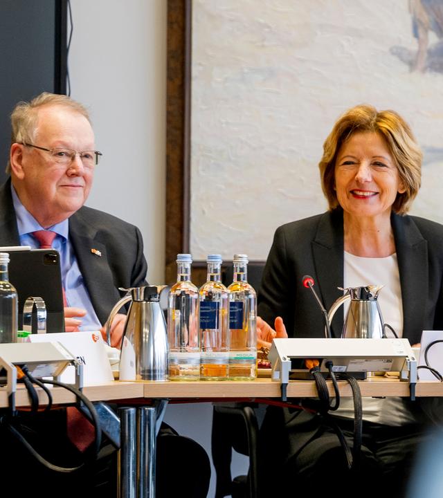 Malu Dreyer, Vorsitzende des ZDF-Verwaltungsrats, und Peter Heesen sitzen nebeneinander während einer ZDF-Verwaltungsratssitzung am Konferenztisch. Das Bild zeigt sie in einer Arbeitssituation mit Technik und Sitzungsunterlagen.