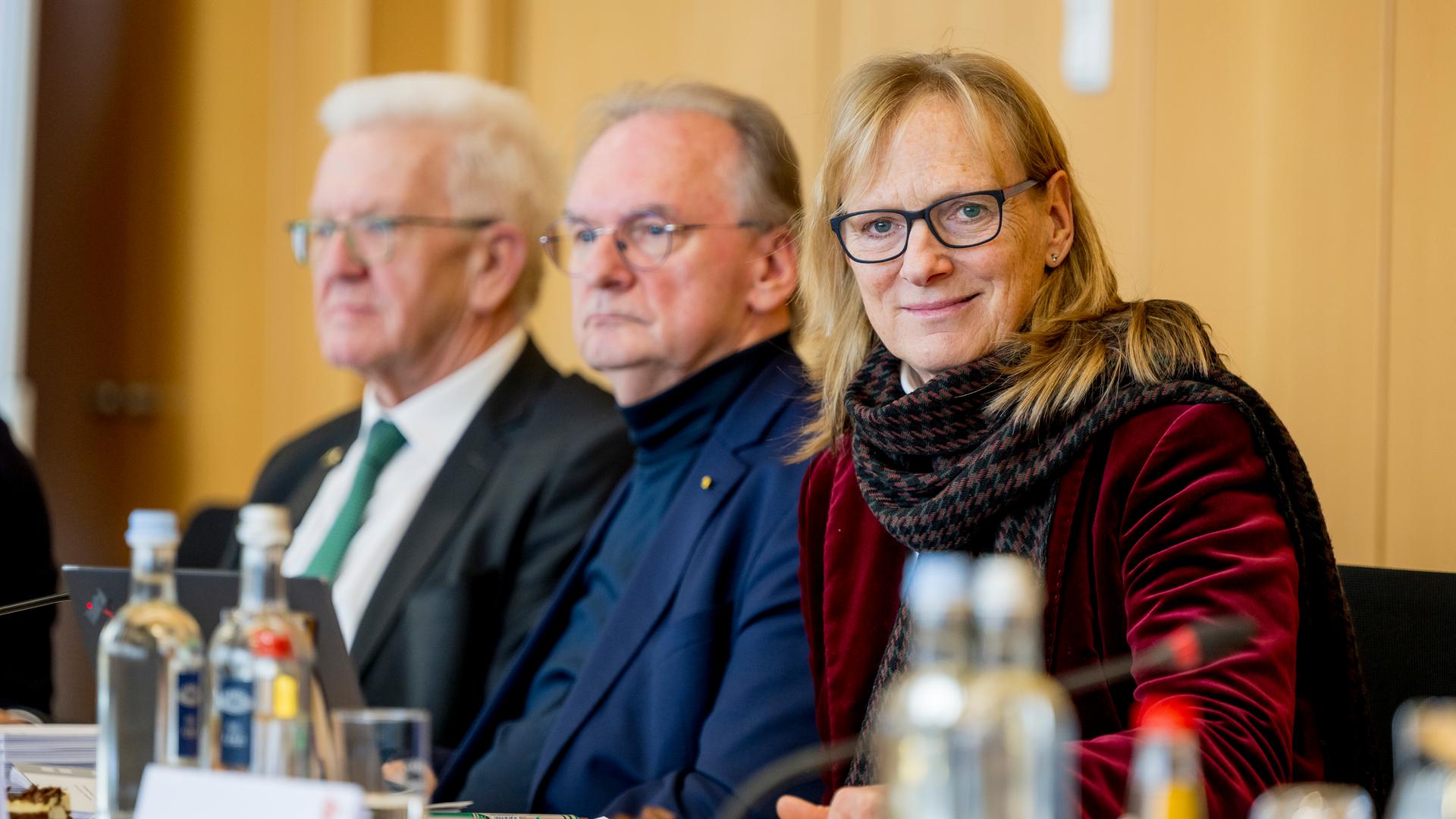 Mitglieder des ZDF-Verwaltungsrates: Prof. Dr. Birgitta Wolff lächelt in die Kamera, während Winfried Kretschmann und Dr. Reiner Haseloff lauschend in die Fernseh sehen