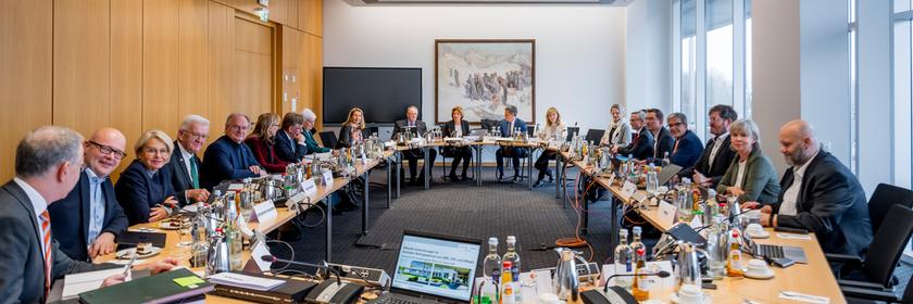 Weitwinkelaufnahme: ZDF-Verwaltungsratssitzung in einem Konferenzraum mit U-förmig angeordneten Tischen und zahlreichen Teilnehmenden. Die Sitzung steht unter dem Vorsitz von Malu Dreyer, auch ZDF-Intendant Norbert Himmler ist anwesend.