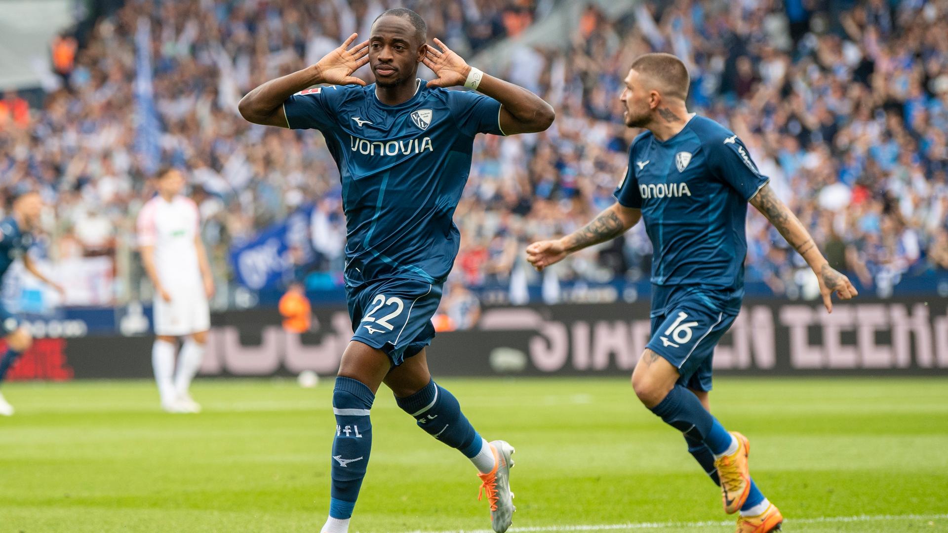 13.05.2023, Nordrhein-Westfalen, Bochum: Fußball: Bundesliga, VfL Bochum - FC Augsburg, 32. Spieltag, Vonovia Ruhrstadion: Bochums Christopher Antwi-Adjei (l) jubelt nach seinem Tor zum 1:0 mit Bochums Kostas Stafylidis.