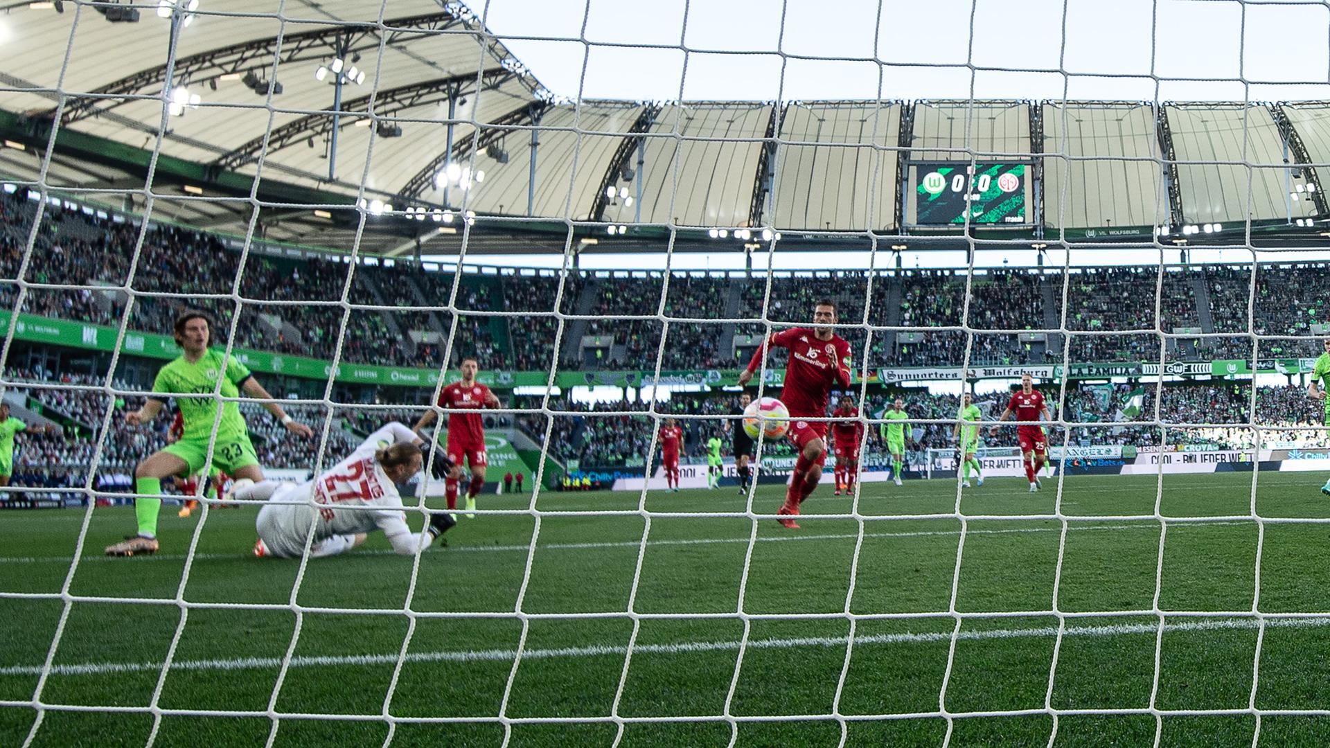 30.04.2023, Niedersachsen, Wolfsburg: Fußball: Bundesliga, VfL Wolfsburg - FSV Mainz 05, 30. Spieltag, Volkswagen Arena. Wolfsburgs Jonas Wind (l) erzielt gegen Mainz Torwart Robin Zentner das Führungstor zum 1:0. 