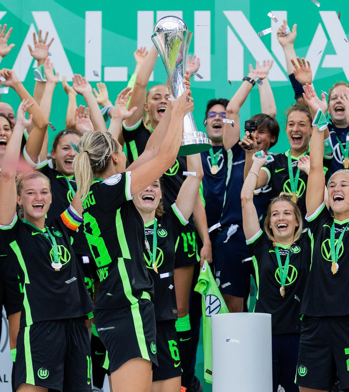 Die Wolfsburgerin Lena Gössling (l) jubelt mit dem Pokal vor ihren Mitspielerinnen am 04.07.2020 in Köln.