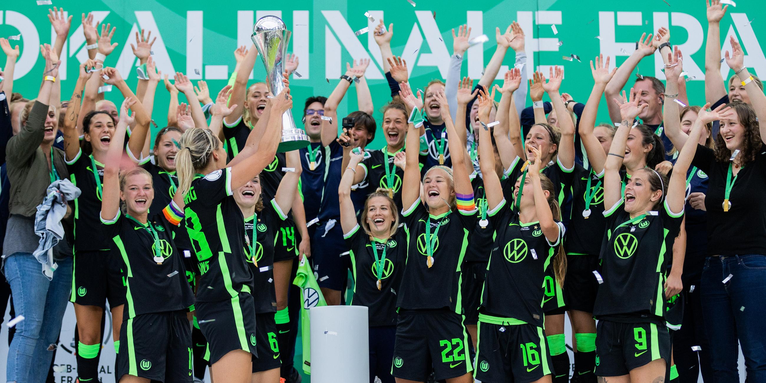 Die Wolfsburgerin Lena Gössling (l) jubelt mit dem Pokal vor ihren Mitspielerinnen am 04.07.2020 in Köln.