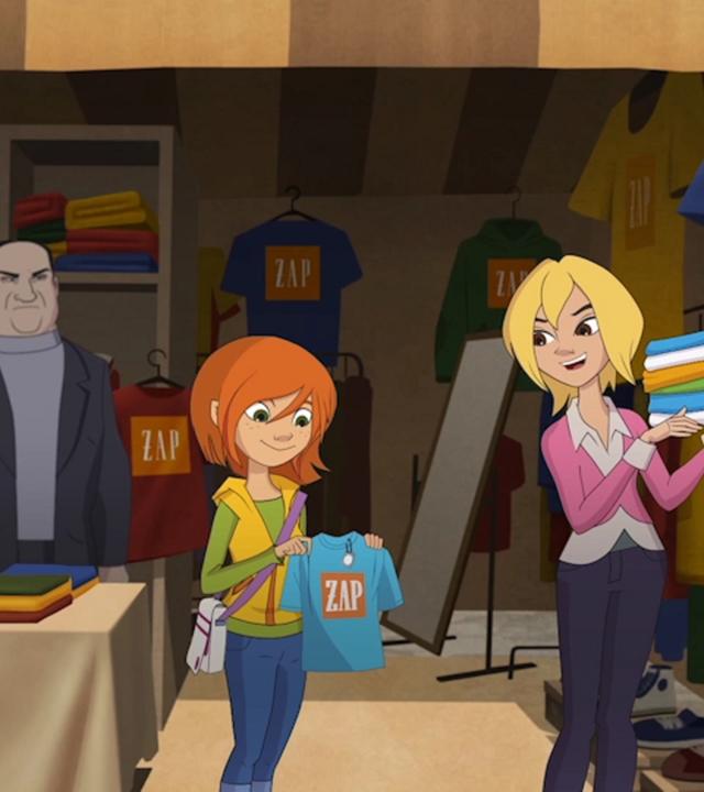 Steffi schaut sich am Flohmarktstand ein T-Shirt genauer an. Die Verkäuferin steht mit einem Stapel Shirts auf dem Arm daneben.