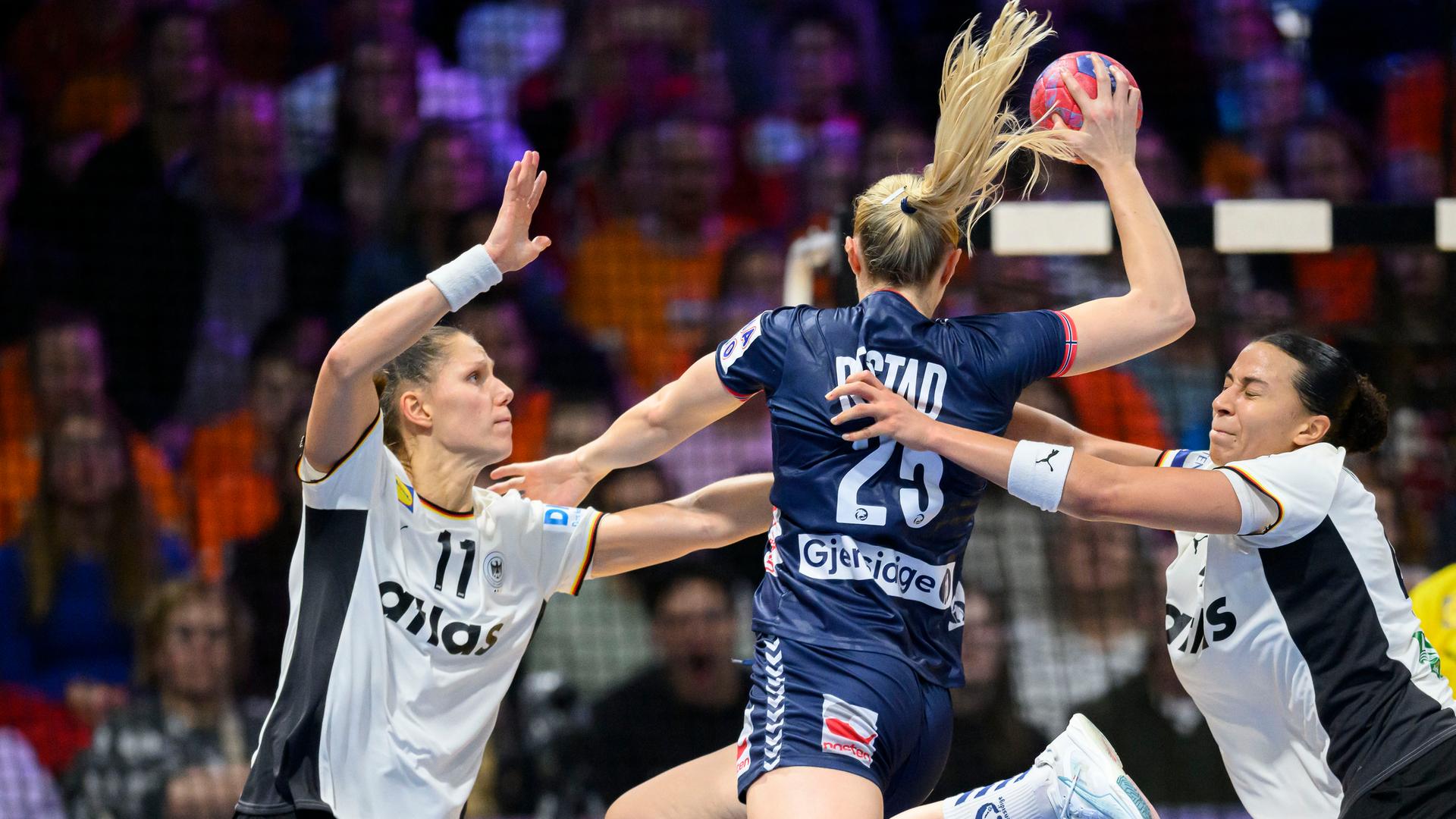 Norwegens Henny Ella Reistad setzt zum Wurf aus dem Sprung auf das deutsche Tor an, wird dabei aber von den deutschen Handballnationalspielerinnen Viola Leuchter und Aimee von Pereira behindert.