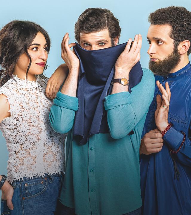  Leila (Cámelia Jordana), Armand (Félix Moati) und Mahmoud (William Lebghil) stehen nebeneinander vor einem hellblauen Hintergrund.Armand steht in der Mitte und hält sich einen dunkelblauen Niqab vor den Mund.