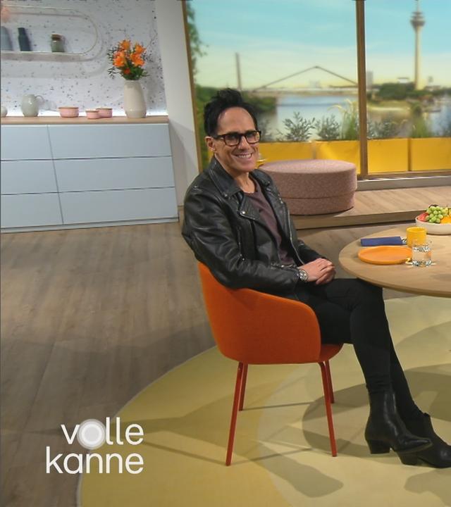 Musiker Andy Brings mit Moderatorin Andrea Ballschuh sitzen am Frühstückstisch im Volle-Kanne-Studio.