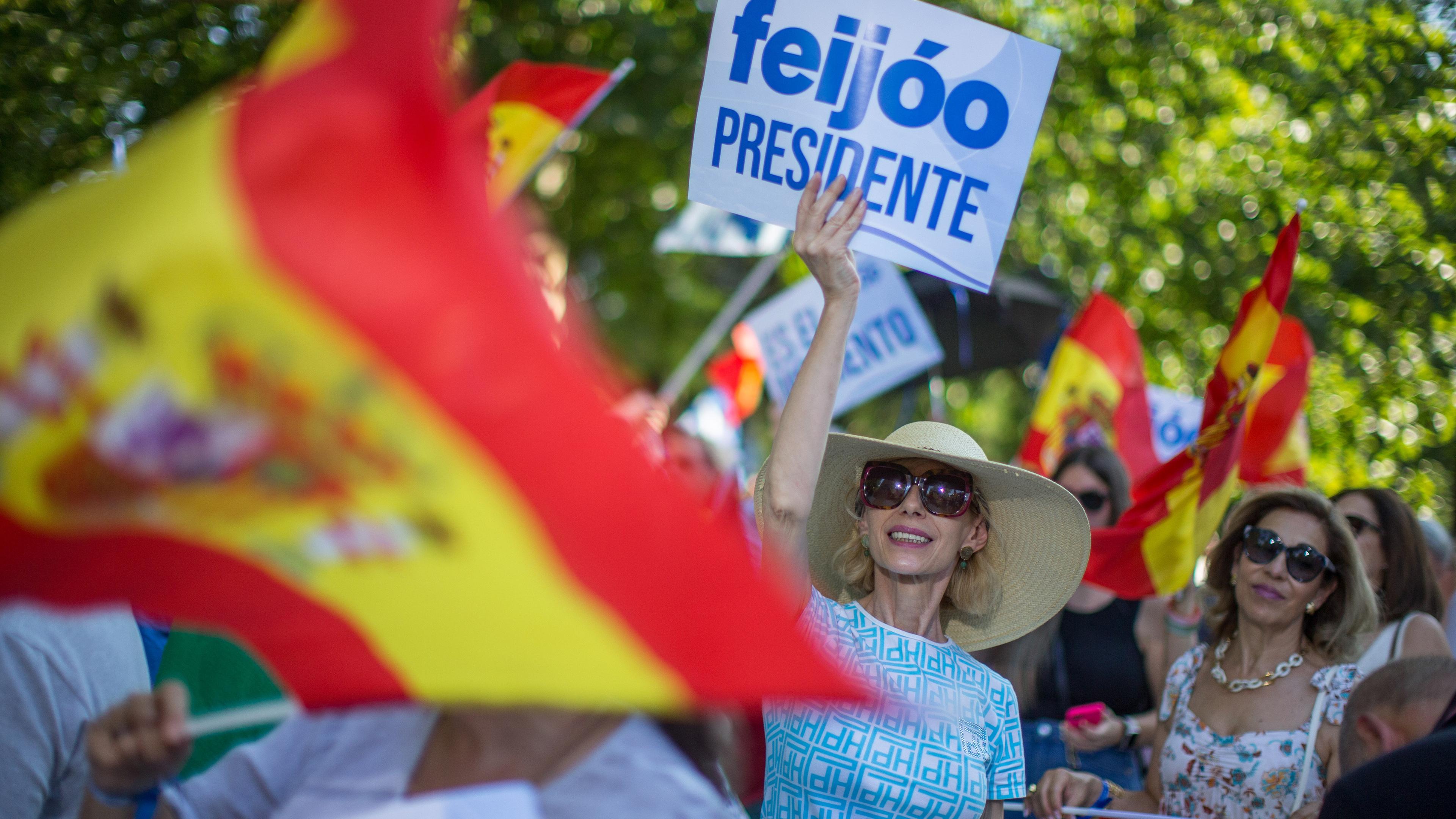 Eine Frau hält während einer Wahlkampfveranstaltung der Volkspartei (PP) in Madrid ein Plakat mit der Aufschrift "Feijoo Präsident".