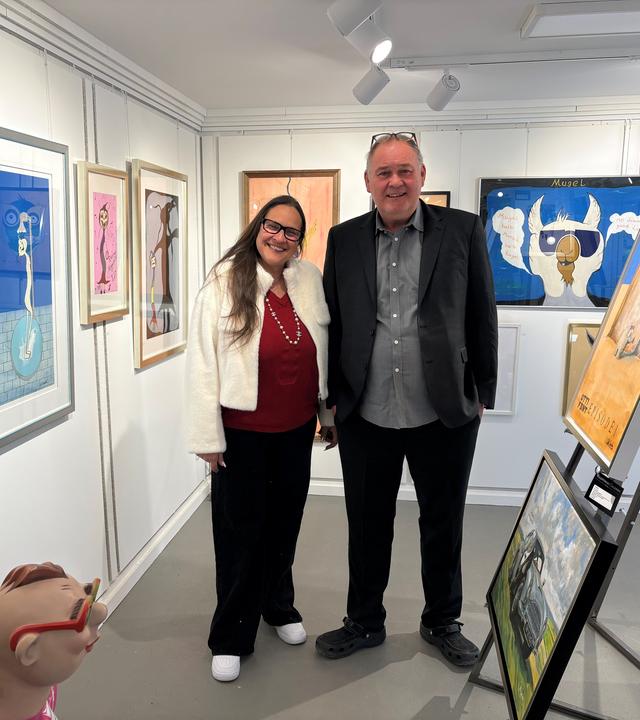 Sonja und Waldi (v. l. n. r.) stehen in einer Kunst-Galerie und lächeln in die Kamera.