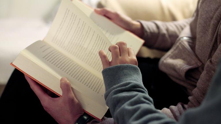 Eine Mutter liest ihrer Tochter aus einem Buch vor.