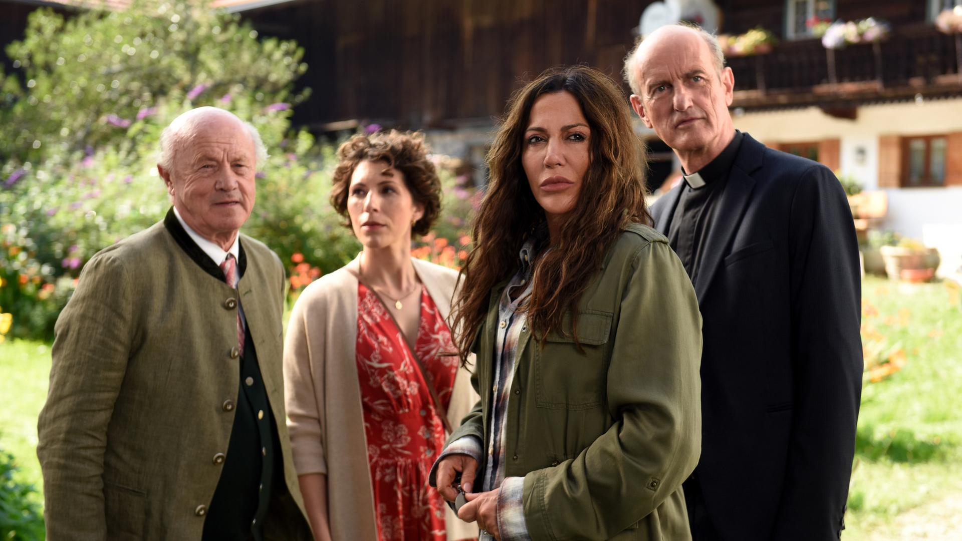 Alois Frankenthal (Hans Stadlbauer), Tatjana Feichtkamm (Eva-Maria Reichert), Katja Baumann (Simone Thomalla) und Pfarrer Sonnleitner (Johannes Herrschmann) stehen vor einem Bauernhaus.