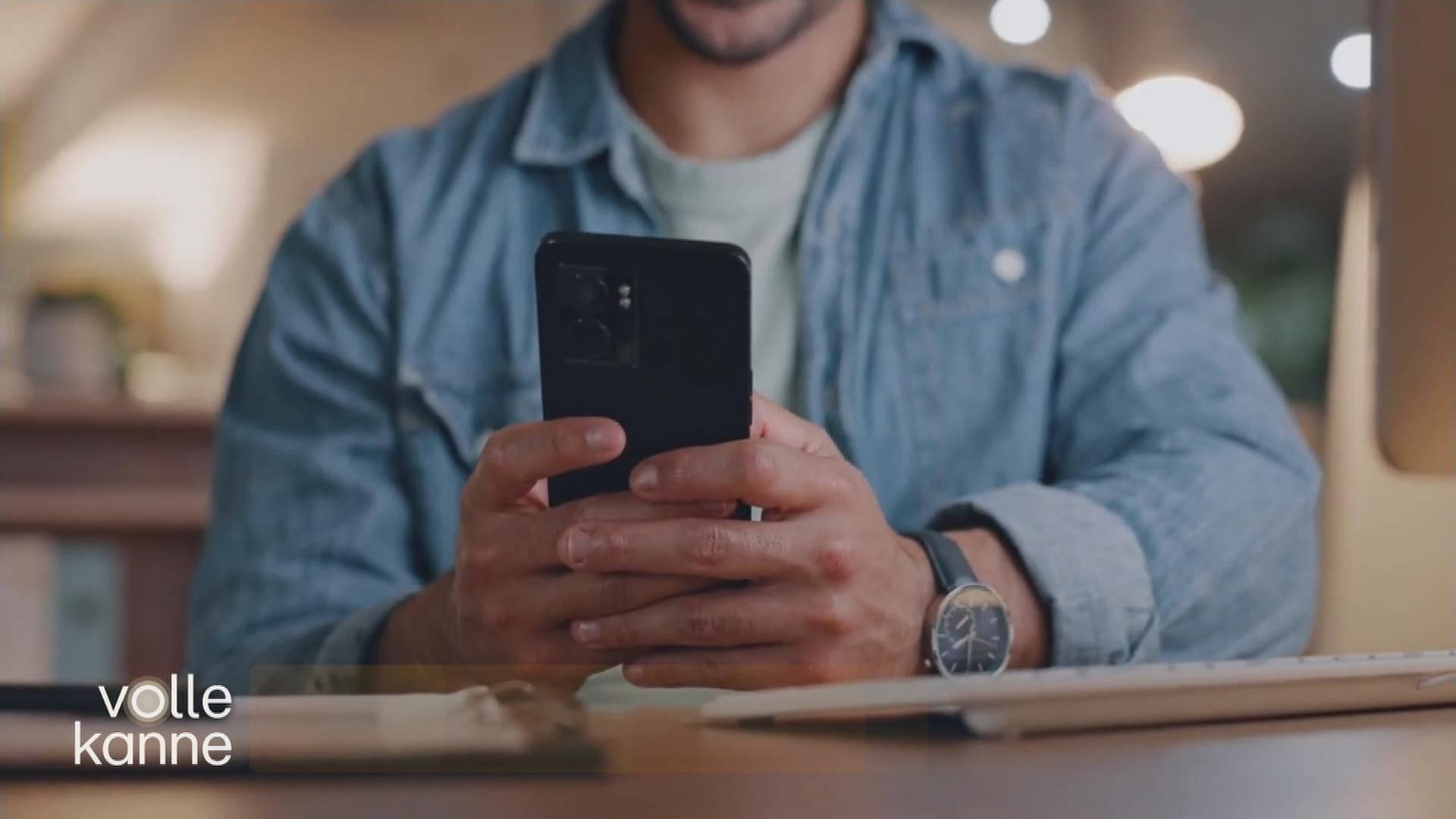 Mann schaut auf ein Handy