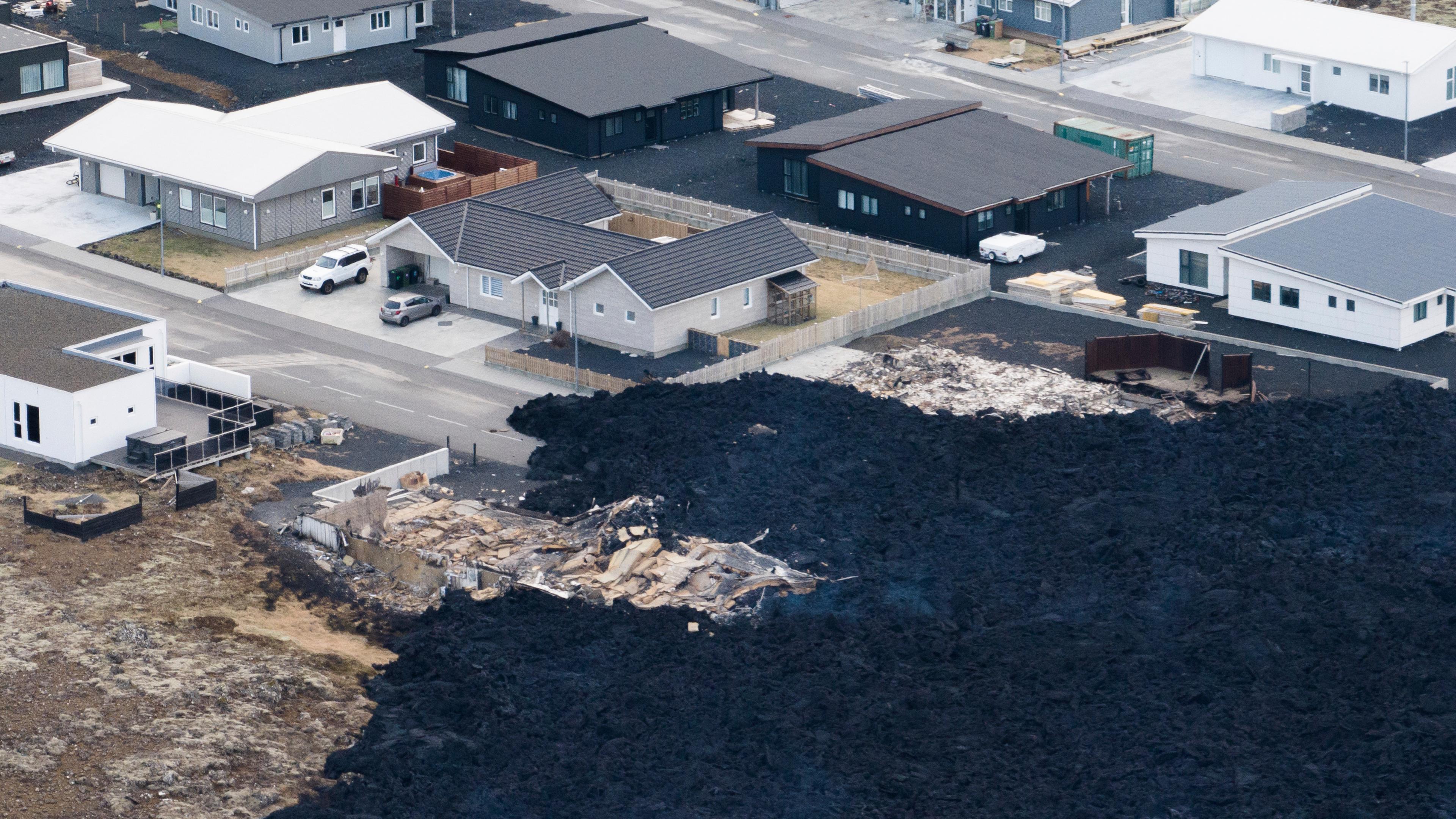 Island, Grindavik: Ein Lavastrom trifft in Grindavík auf ein Wohngebiet.