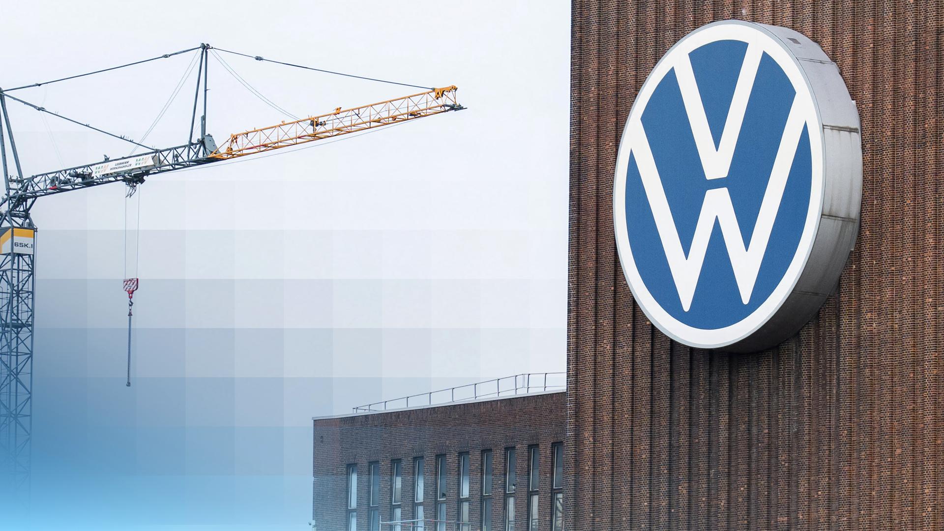 VW Zeichen an einem Gebäude. Im Hintergrund ein Baukran