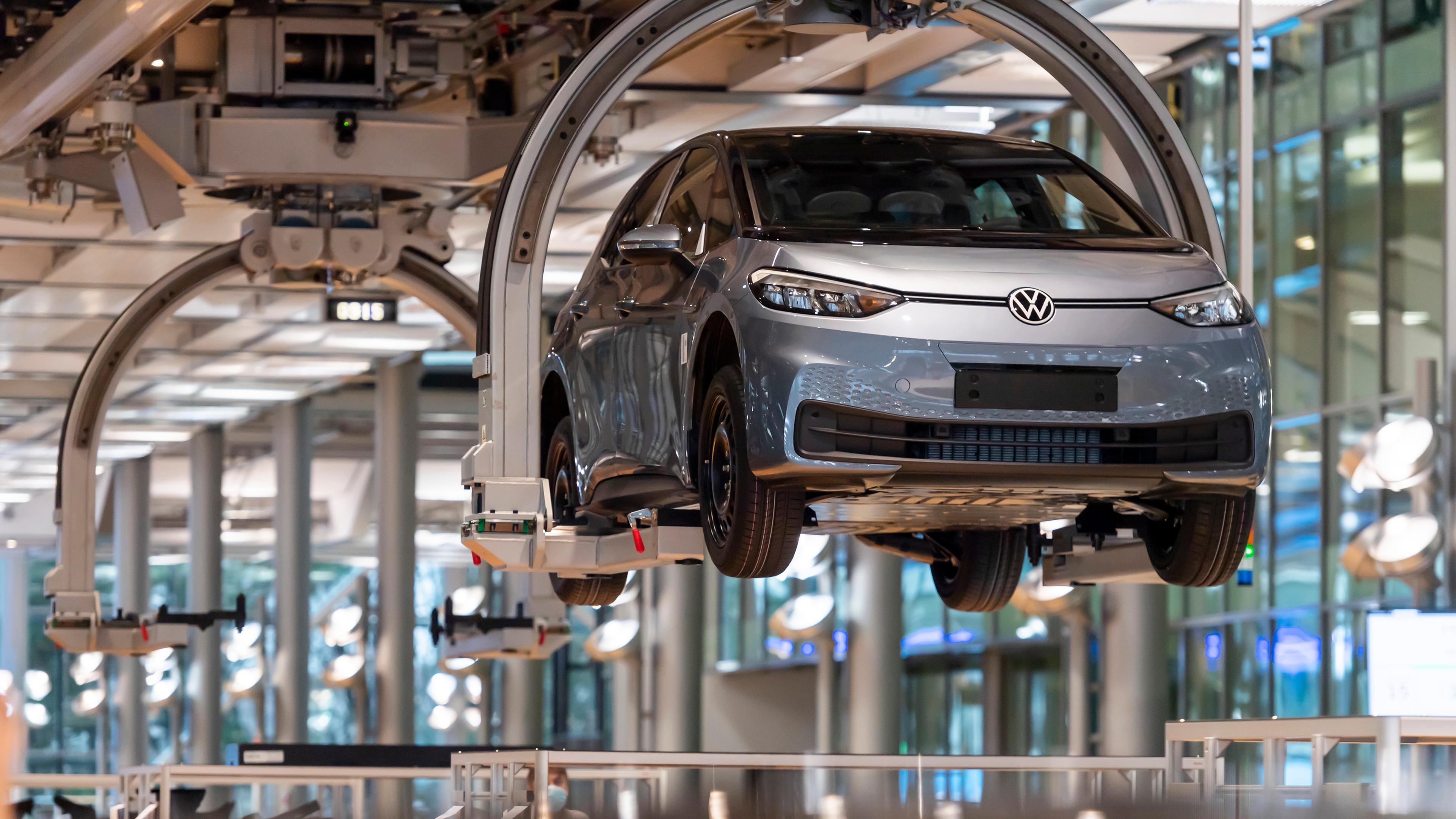 Ein Auto schwebt am Fließband durch die Montagehalle im VW-Produktionswerk.