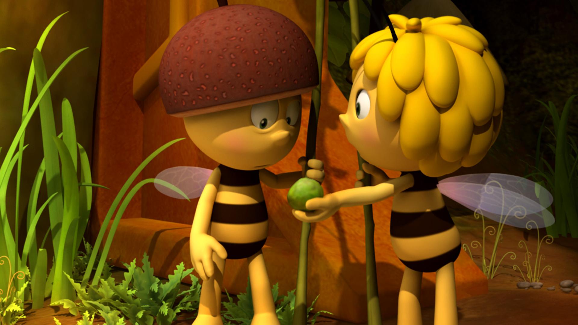 Willi als Wachbiene. Er hat einen Helm auf und einen Speer in der Hand. Maja hält ihm eine grüne Polle hin.