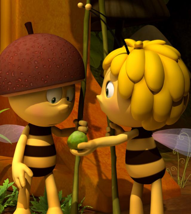 Willi als Wachbiene. Er hat einen Helm auf und einen Speer in der Hand. Maja hält ihm eine grüne Polle hin.