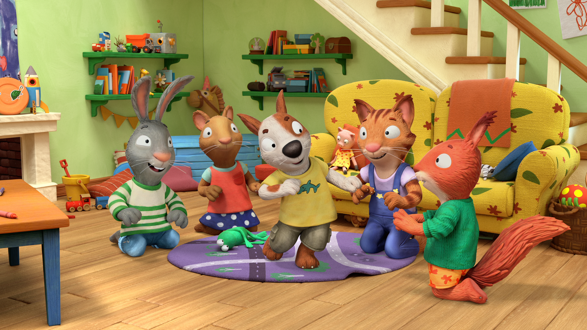 Im Wohnzimmer steht Zac in der Mitte und tanzt. Um ihn herum sitzen Pip, Posy, Frankie und Jamila und schauen ihm glücklich zu.