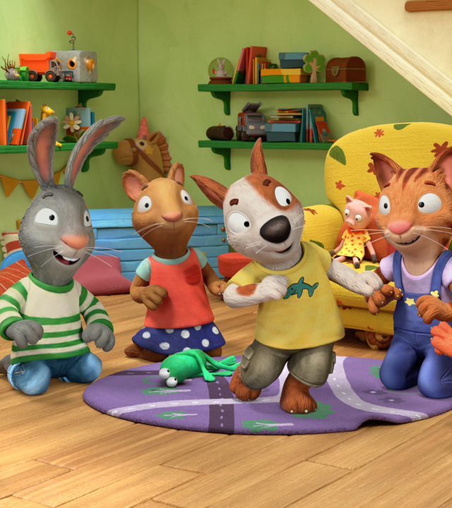 Im Wohnzimmer steht Zac in der Mitte und tanzt. Um ihn herum sitzen Pip, Posy, Frankie und Jamila und schauen ihm glücklich zu.