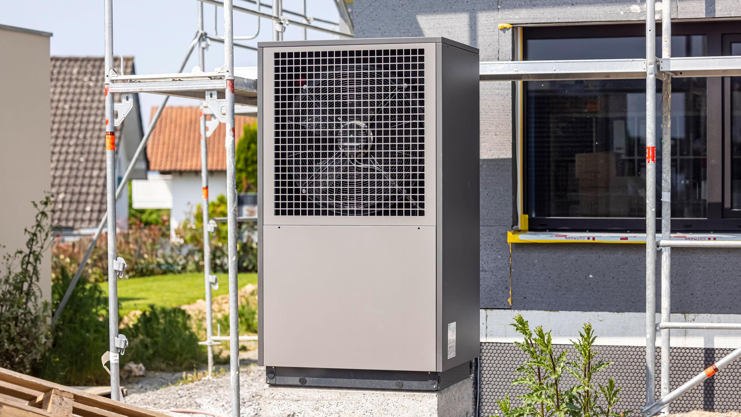 Wärmepumpe im Garten eines neuen Wohnhauses
